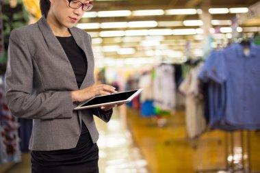 Alışveriş merkezinde tablet kullanan kadın.