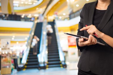 Alışveriş merkezinde dijital tablet kullanarak iş kadını.