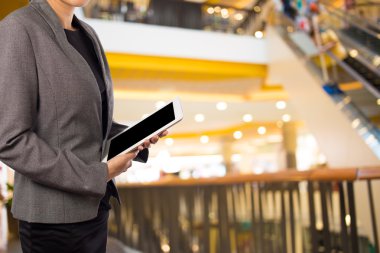 Alışveriş merkezinde dijital tablet kullanarak iş kadını.