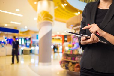 Alışveriş merkezinde dijital tablet kullanarak iş kadını.