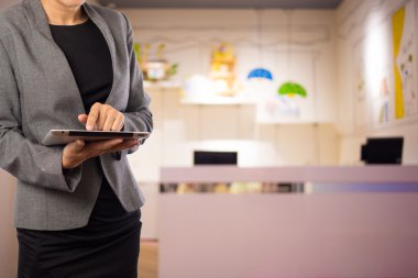 Alışveriş merkezinde dijital tablet kullanarak iş kadını.