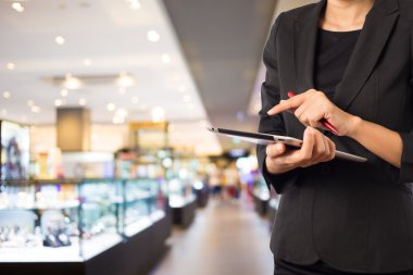 Alışveriş merkezinde dijital tablet kullanarak iş kadını.