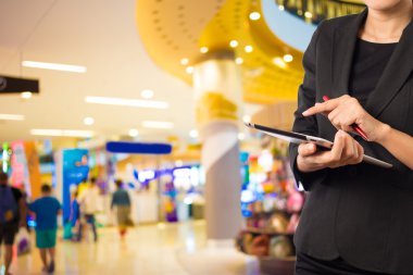 Alışveriş merkezinde tablet kullanan kadın.