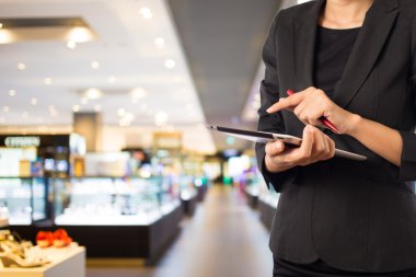 Alışveriş merkezinde tablet kullanan kadın.