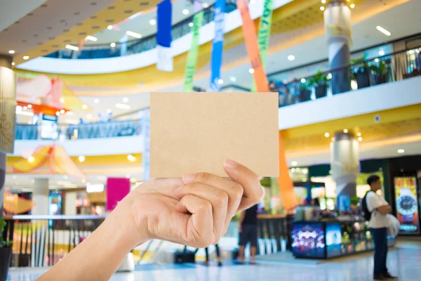 Foto em branco. Mão segurar cartão de visita em branco no shopping . — Fotografia de Stock