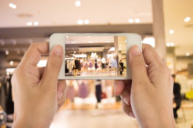 Alışveriş alışveriş merkezinde bir cep telefonu fotoğraf çekmeye kadın.