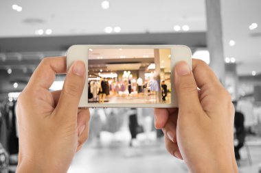 Alışveriş alışveriş merkezinde bir cep telefonu fotoğraf çekmeye kadın.