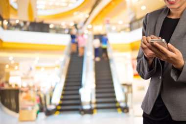 Akıllı telefon alışveriş merkezinde kullanarak iş kadını.