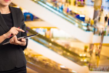 Alışveriş merkezinde tablet kullanan kadın.