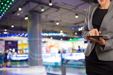 Alışveriş merkezinde tablet kullanan kadın.