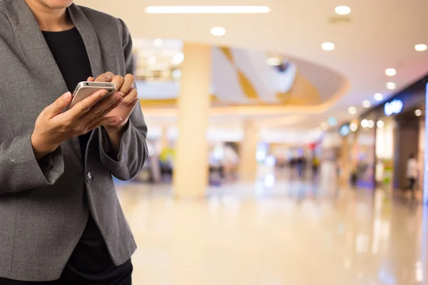 Affärskvinna med smart telefon i köpcentrum. — Stockfoto