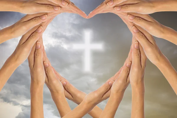 Ręce uczynić kształt serca i chrześcijańskiej krzyż na niebie. — Zdjęcie stockowe