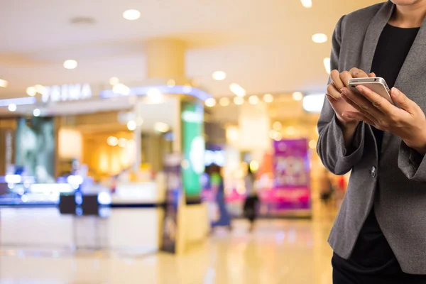 Kvinnor i köpcentrum med mobiltelefon. — Stockfoto