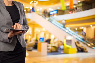 Alışveriş merkezinde tablet kullanan kadın.