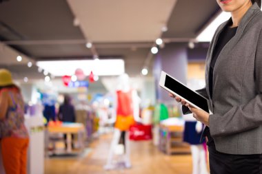 Alışveriş merkezinde tablet kullanan kadın.
