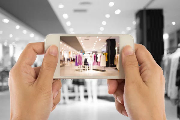 Tirar uma foto com um telefone inteligente no shopping . — Fotografia de Stock