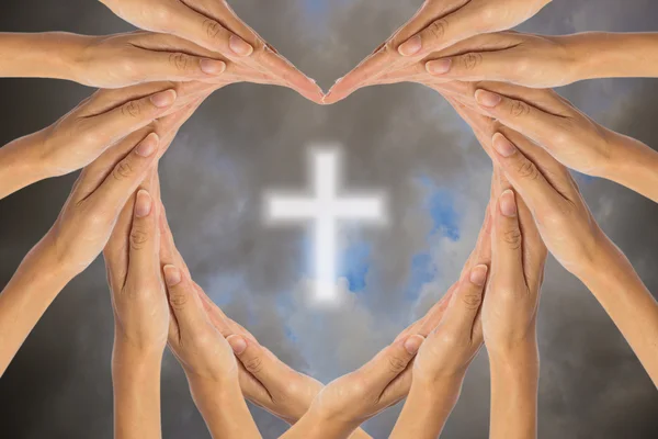 Kéz, hogy szív alakú és keresztény kereszt az égen. — Stock Fotó