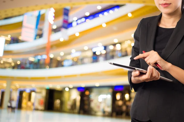 Alışveriş merkezinde tablet kullanan kadın.