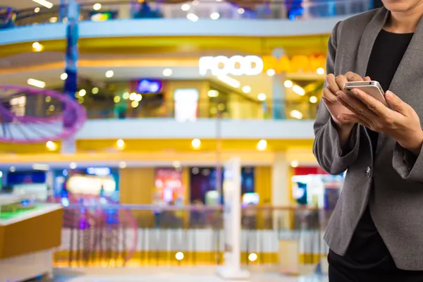 Kvinnor i köpcentrum med mobiltelefon. — Stockfoto