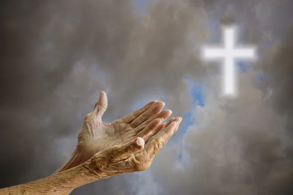 Üst düzey kadın üzerinde dua eller gökyüzü çarmıhta bulanık — Stok fotoğraf