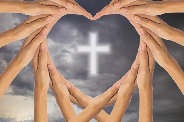 Ręce serce kształt krzyża na tle nieba. — Zdjęcie stockowe