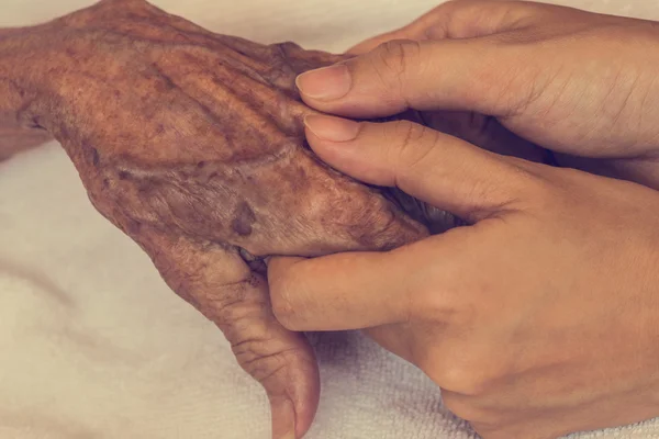 Mão de mulher tocando mulher idosa na clínica. : Filtro vintage — Fotografia de Stock