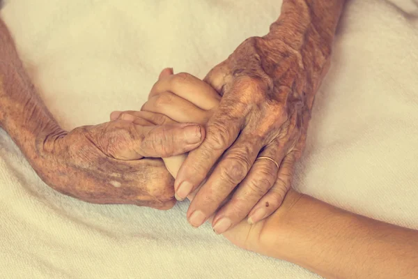 Hand van vrouw aanraken senior vrouw in de kliniek. : Vintage filter — Stockfoto