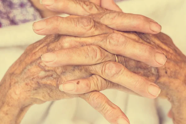 Hand van vrouw aanraken senior vrouw in de kliniek. : Vintage filter — Stockfoto