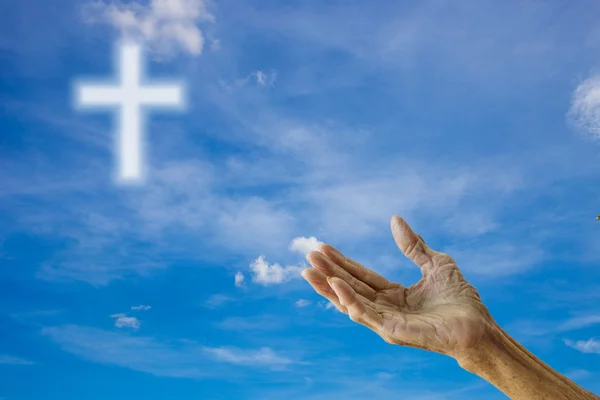 Yaşlı kadının elleri üzerinde dua gökyüzü çarmıhta bulanık — Stok fotoğraf