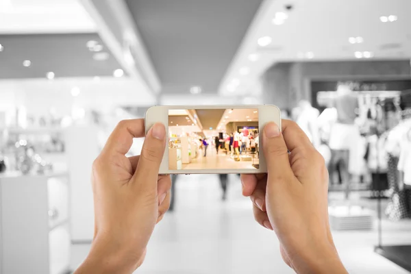 Ta en bild med en smart telefon i köpcentrum. — Stockfoto