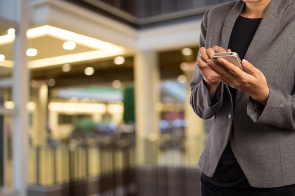 Kvinnor i köpcentrum med mobiltelefon. — Stockfoto