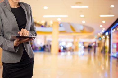 Alışveriş merkezinde tablet kullanan kadın.