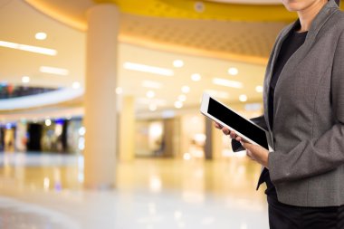 Alışveriş merkezinde dijital tablet kullanarak iş kadını.