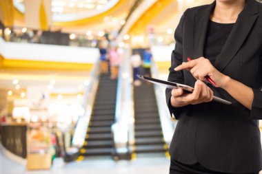Alışveriş merkezinde dijital tablet kullanarak iş kadını.