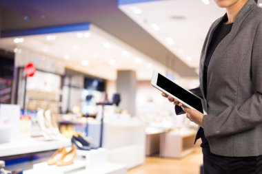 Alışveriş merkezinde dijital tablet kullanarak iş kadını.
