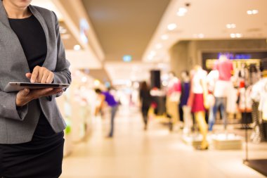 Alışveriş merkezinde dijital tablet kullanarak iş kadını.