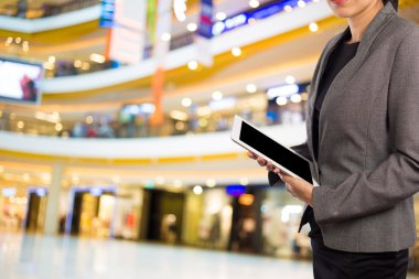 Alışveriş merkezinde dijital tablet kullanarak iş kadını.