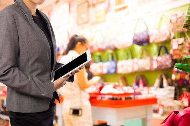 Alışveriş merkezinde dijital tablet kullanarak iş kadını.