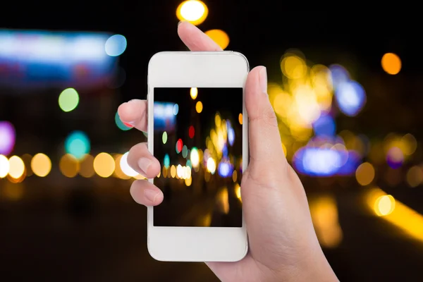 Donne mano tenendo vuoto smartphone cellulare e luce notturna della città — Foto Stock
