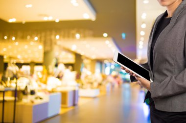 Alışveriş merkezinde dijital tablet kullanarak iş kadını.
