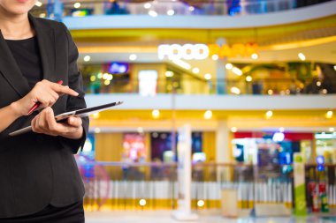 Alışveriş merkezinde dijital tablet kullanarak iş kadını.