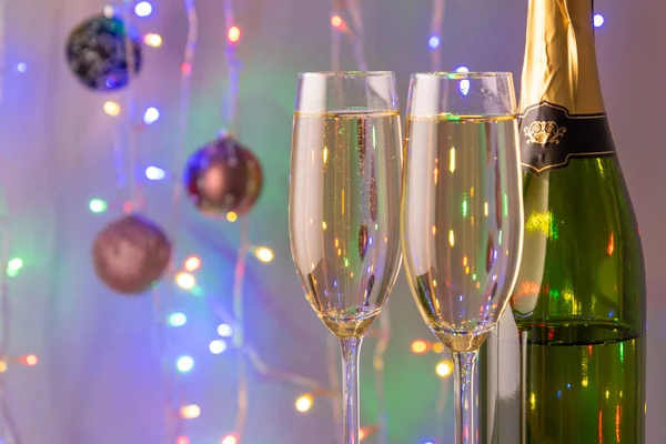 Yeni yıl şampanyası, Noel ışıkları arka planda şenlikli süslemeler.