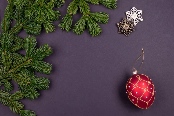 Renkli Noel süslemeleri ve koyu gri arka planda köknar dalları olan şenlikli kompozisyon — Stok fotoğraf