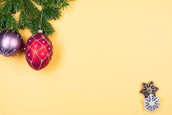 Noel süslemeleri, parlak sarı arka planda köknar dalları — Stok fotoğraf
