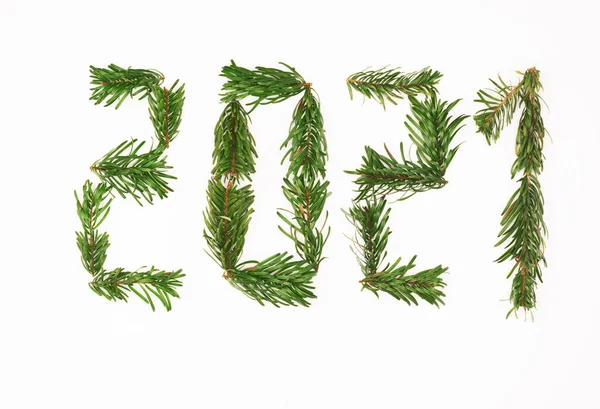 number 2021 made with small branches of fir tree on white background, isolated. New years theme.