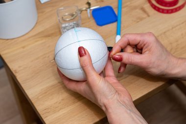 Bir kadının elleri Noel ağacı için süsleme yapıyor. Hobi fotoshoot