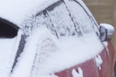 Koyu renk araba gövdesi karlı kış gününde kapanıyor..