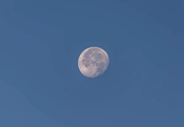 Pełnia księżyca widziana na błękitnym niebie przez obiektyw kamery — Zdjęcie stockowe