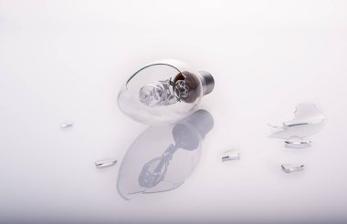 Yansıma ve cam parçalarıyla yakın plan kırık ampul.,