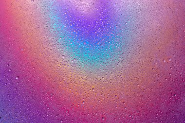 Çok renkli yüzeyde bir damla su. Makro fotoğraf, damla, gölge plastik taban.